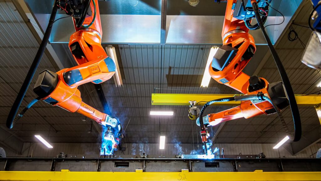 Two CLOOS robotic arms in action at Starland Metals performing a high-precision welding operation on a large metal component.